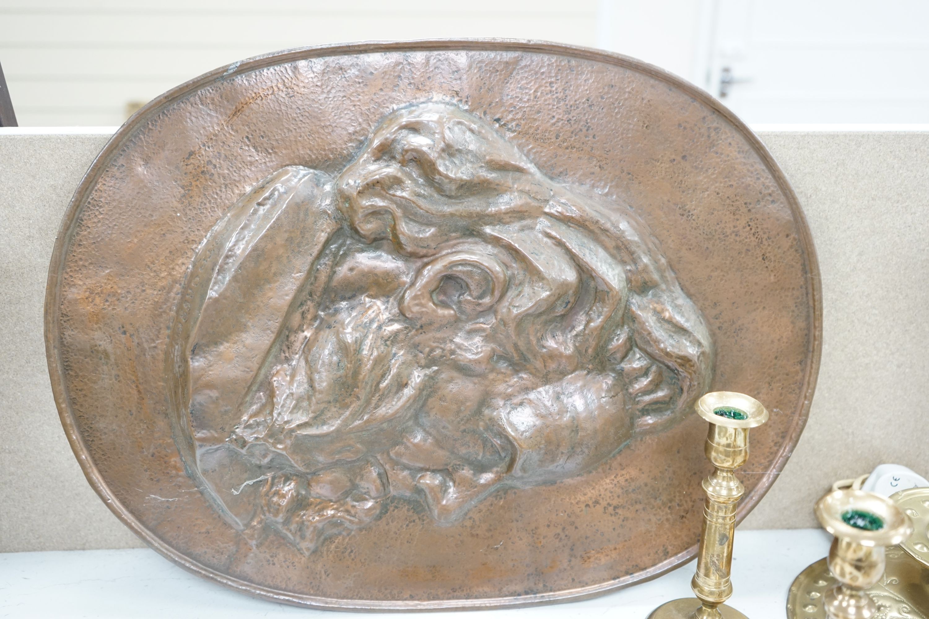 An embossed brass lamp, lustre drop wall light, a pair of bell-metal candlesticks, an 18th century pewter plate and a large Swedish embossed plaque